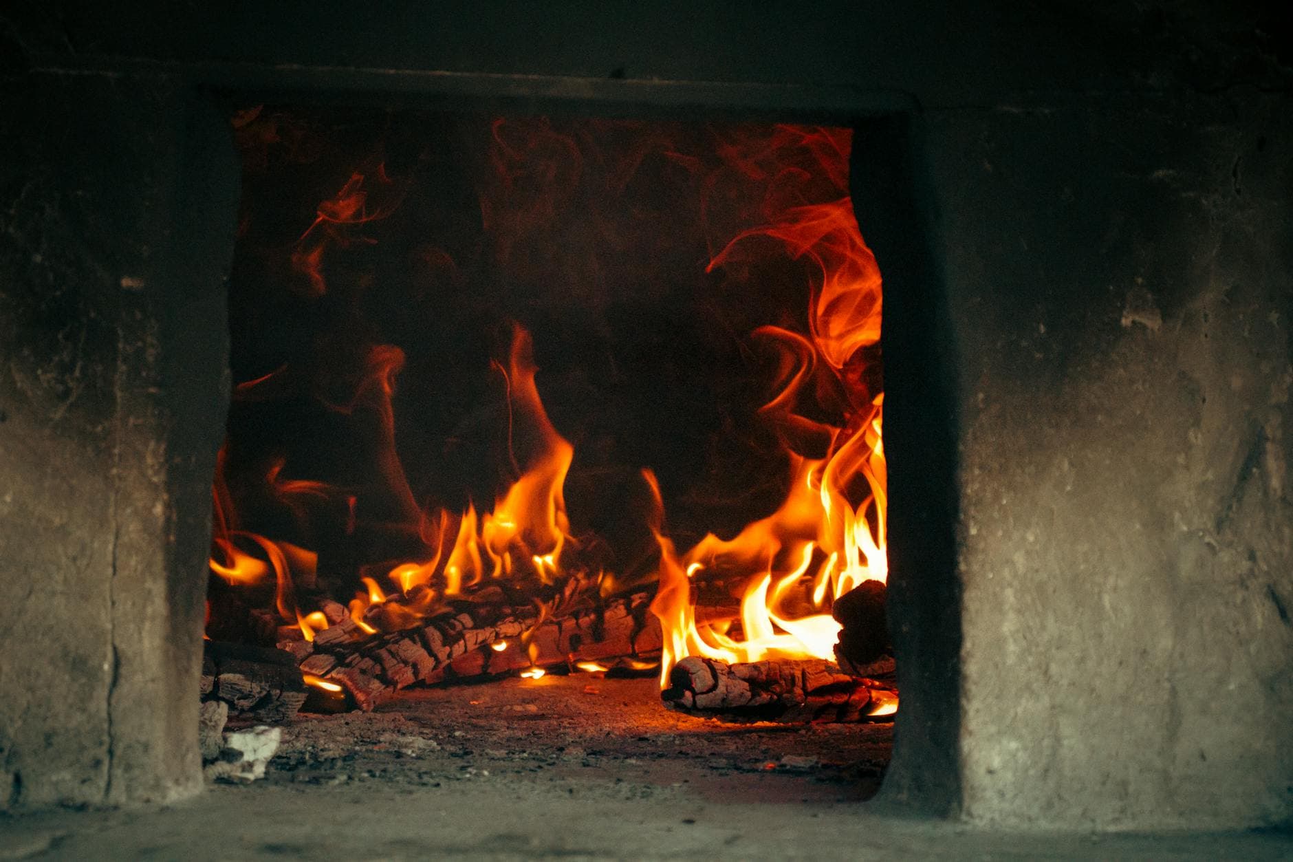A rustic fireplace with burning logs creating a warm and cozy atmosphere.